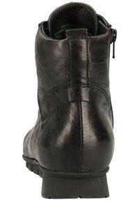 Černá kožená kotníková bota s hladkým povrchem, bočním zipem a nízkým gumovým podpatkem. Obsahuje šité detaily a zaoblenou špičku.