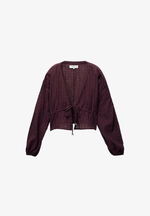 Burgundowa, skrócona bluzka z długimi rękawami, teksturowany materiał, dekolt w kształcie litery V i z przodu wiązanie. Posiada małe dekoracyjne guziki wokół dekoltu.