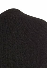 Schwarzer Pullover mit gerippter Textur, runder Ausschnitt und glatter Verarbeitung. Das Material wirkt weich und elastisch.