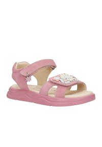 Sandale rose pour enfants avec des sangles ajustables, une semelle souple, des décorations florales sur la sangle avant, et un petit pendentif en forme de fleur sur la sangle latérale.