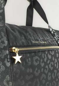 Černá nylonová taška s leopardím vzorem, zlatým zipem a hvězdičkovým přívěskem. Disponuje dvojitými černými popruhy a hladkým povrchem.
