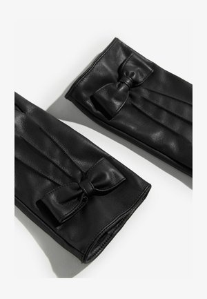 Mustad mustrinäomistega mustad nahkkindad, millel on pleedi muster ja dekoratiivne pael, sujuva tekstuuri ja hästi istuva kujuga.