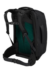 Sac à dos noir avec des bretelles ajustables, contenant un rembourrage dorsal texturé vert et une poche zippée sur le côté. Tissu durable et design ergonomique.