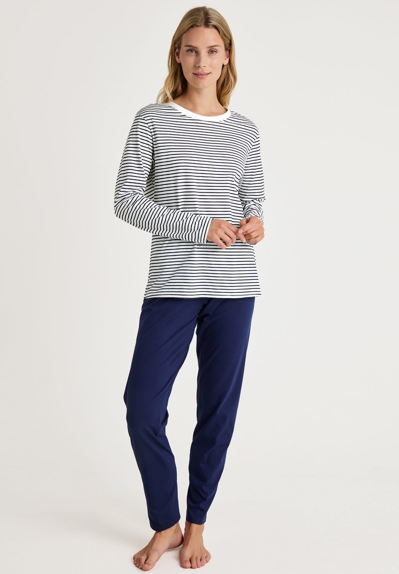 Gestreept overhemd met lange mouwen in wit en marineblauw, gecombineerd met effen marineblauwe broek. Zachte stof met een relaxed fit en ronde halslijn.