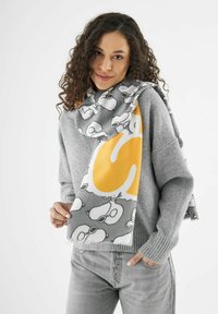 Écharpe grise avec un motif de bande dessinée de Snoopy, ornée d'un grand accent jaune en forme de "S", fabriquée en tissu doux avec des bords effilochés.