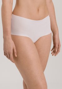 Seamless, soft cotton hipster underwear in light pink, featuring a wide waistband and a smooth, minimalist design without visible seams.