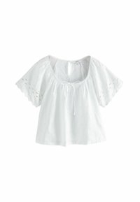 Hvid bomuldsbluse med løs pasform, bølgede ærmer og hulmønster broderi. Har en rund halsudskæring med en bindebåndsdetalje og nøglehulryg.