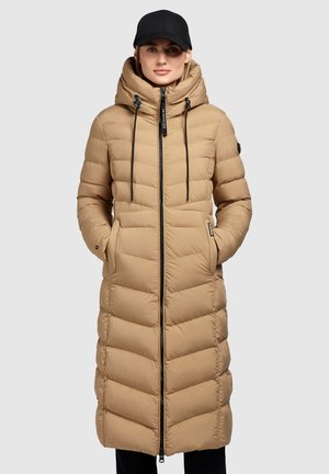 Manteau en duvet beige avec capuche, longueur longue, design matelassé vertical, fermeture éclair devant et cordons de serrage ajustables. Accents noirs, deux poches latérales.