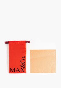 Pungă din fabrică roșie cu litere negre "MAX & Co.", lângă o cârpă pătrată bej, imprimată cu "MAX" și "Co." într-un model subtil.