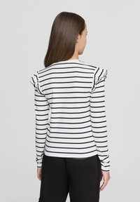 Maglietta a maniche lunghe a righe in bianco e blu navy, con accenti arricciati sulle spalle, tessuto morbido, vestibilità slim e orlo arrotondato.