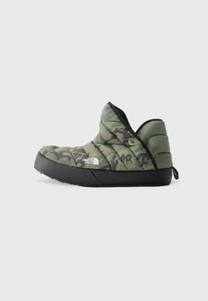 Scarpa slip-on in camouflage verde trapuntato con suola in gomma nera. Dotata di collare imbottito e linguetta sul retro per indossarla facilmente.