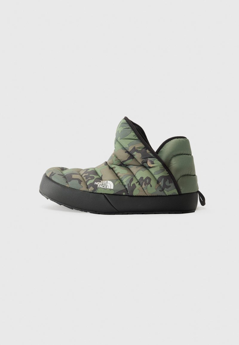 Grønn camo-quiltet slip-on sko med svart gummisåle. Har polstret krage og bakre trekkrem for enkel påkledning.
