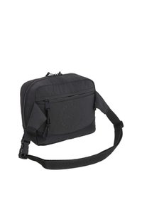Čierna crossbody taška vyrobená z textúrovanej tkaniny. Má zipsové uzatváranie, nastaviteľný popruh a embosované logo na prednej strane. Kompaktný dizajn.