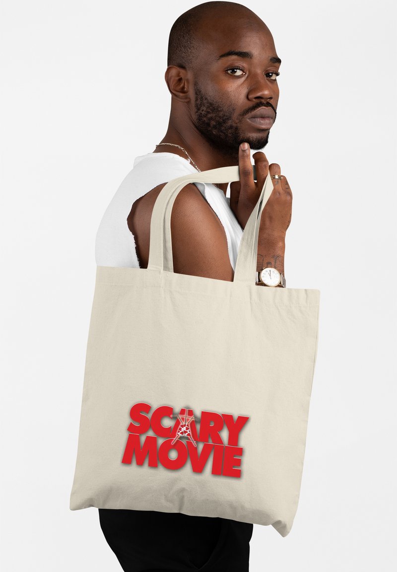 Borsa tote in tela beige con manici robusti. Presenta una scritta audace in rosso che recita "FILM HORROR" con un design di ragnatela integrato nel testo.