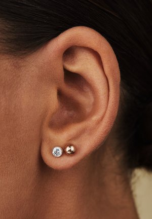 Boucles d'oreilles en or rose avec un cristal transparent en pièce maîtresse et un accent en boule ronde lisse, présentant une finition polie et un design minimaliste.