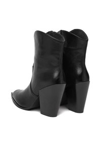 Czarne skórzane buty za kostkę z szpiczastym noskiem i solidnym obcasem. Gładka tekstura z delikatnym połyskiem i charakterystycznym wzorem przeszyć.