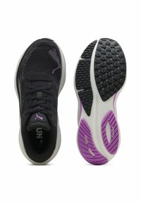 Baskets de sport noires avec une tige en maille, accents violets et un col rembourré. Elles disposent d'une semelle extérieure en caoutchouc texturé pour l'adhérence et la flexibilité.