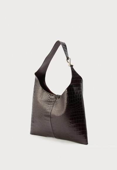 Σκούρα καφέ τσάντα ώμου από δέρμα με μοτίβο κροκοδείλου, με πλατιά τιράντα και μεταλλικό κούμπωμα, εμφανιζόμενη σε απλό λευκό φόντο.