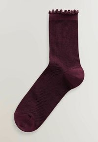 Bordeauxfarvet ribstrømpe med en flæset kant øverst, der har en glat tekstur samt forstærket hæl og tå for holdbarhed.