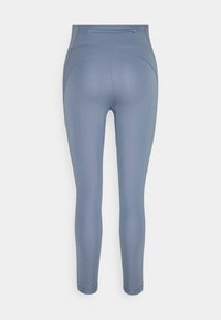Legginsy z wysokim stanem w miękkim niebieskim materiale o gładkiej strukturze. Posiadają tylną kieszeń oraz zaokrąglone przeszycia w okolicy bioder.