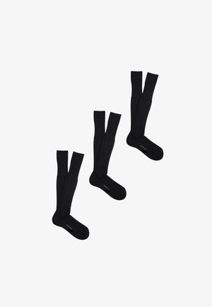 Tre paia di calzini neri al ginocchio disposti diagonalmente, ciascuno con la parola "PEROFIL" visibile nella zona del piede.