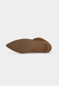 Chaussure en daim marron à bout pointu montrée par la semelle, avec le logo "paul green" et l'étiquette de taille sur la semelle.
