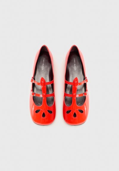 Red patent leather ballet flats with cut-out flower design, double adjustable straps, and smooth black lining.