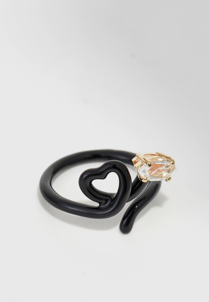 Fekete, rugalmas, szív formájú spirálgyűrű; tiszta dekoratív kő arany színű fémrészekben.