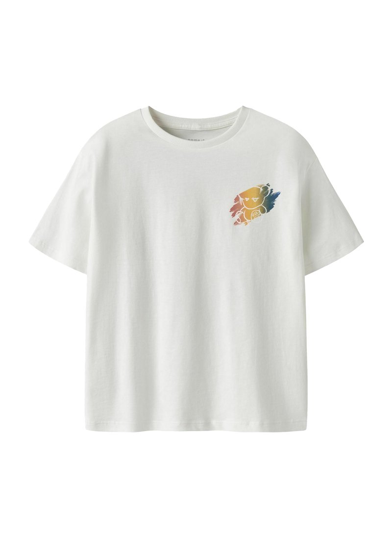 T-shirt blanc à manches courtes avec une petite illustration colorée de chat sur le côté gauche de la poitrine.