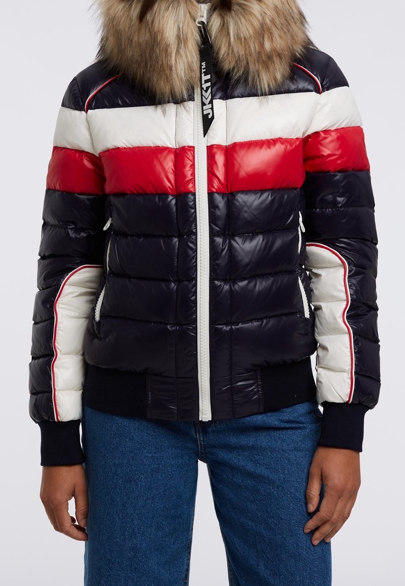 Veste en duvet bleu marine, rouge et blanc avec un col en fourrure, présentant une fermeture éclair à l'avant, des poignets côtelés et un design matelassé horizontal.