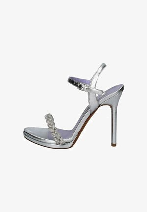 Sandalo con tacco alto argentato, dotato di una cintura testurizzata, fibbia alla caviglia e un dettaglio decorativo intrecciato. Presenta una finitura lucida e un sottopiede viola.