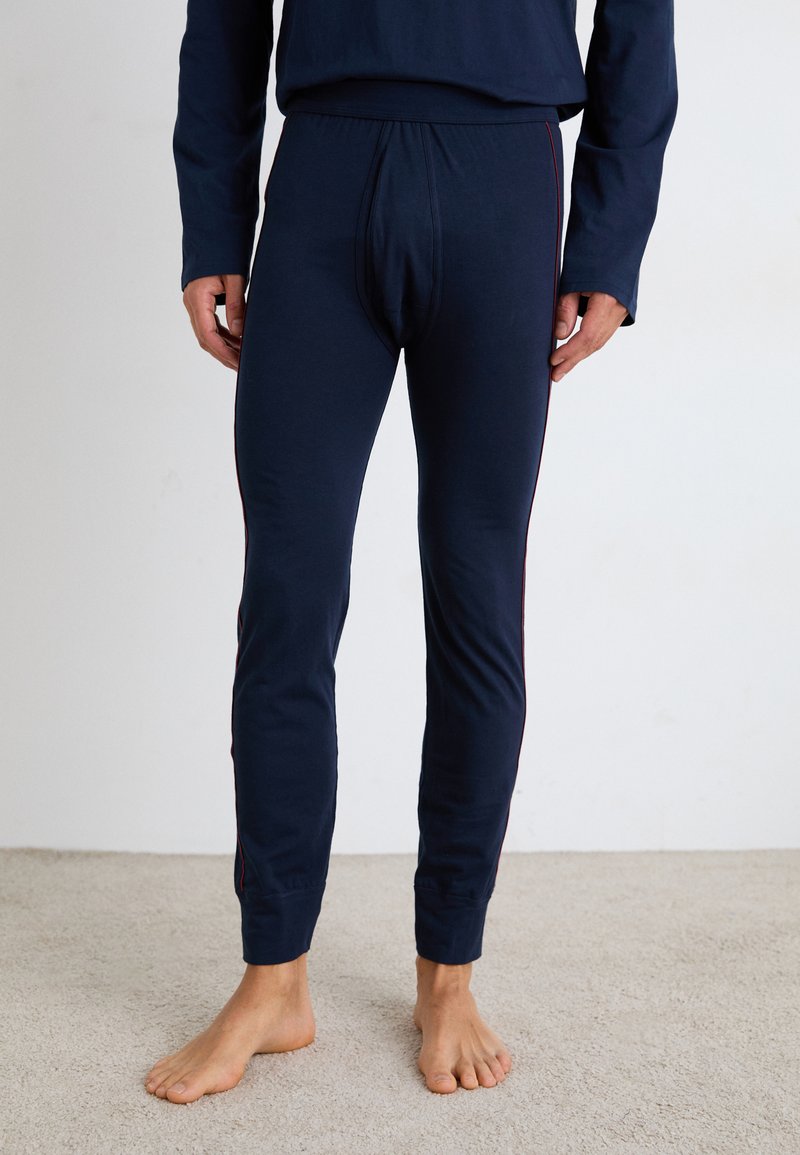 Marineblaue lange Unterwäsche mit enganliegendem Design, mit einem gerippten Bund und kontrastierenden roten Seitenstreifen. Aus weichem Baumwollmaterial, minimaler Textur.