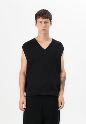 Pullover nero senza maniche con scollatura a V, realizzato in materiale a coste. Presenta una vestibilità morbida e una texture liscia.