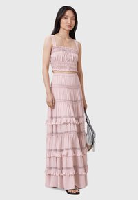 Conjunto de dos piezas rosa claro que incluye una blusa corta con escote cuadrado y fruncido, y una falda maxi con volantes y capas.