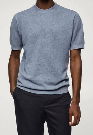 Kurzärmeliger, hellblauer Strickpullover mit Rundhalsausschnitt, gerippten Bündchen und Saum, getragen über einer dunklen Hose. Strukturierter, lässiger Stil.