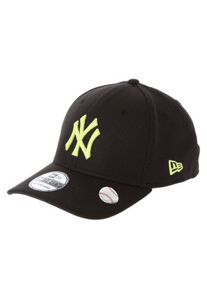Casquette de baseball noire avec logo NY jaune néon à l'avant, logo de la marque sur le côté, et étiquettes de taille et de baseball sur la visière.