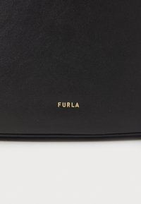 Černá kožená taška s texturovaným povrchem, se zlatým logem "FURLA" na spodní straně. Jednoduchý, obdélníkový design bez dalších akcentů.