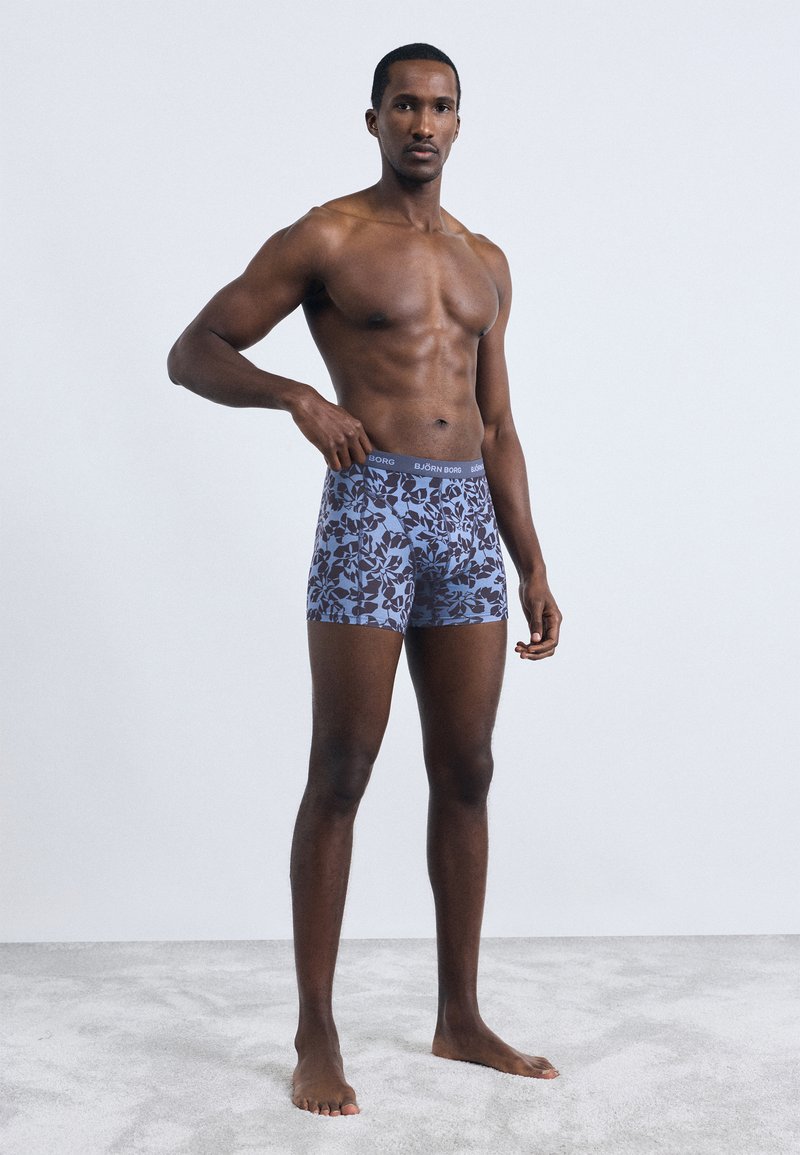 Férfi boxer shorts kék színben, virágmintával, fekete elasztikus derékpánttal, amelyen a "BJÖRN BORG" felirat olvasható. Puha anyagú, testhez álló fazon.