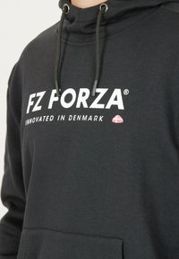 Svart sweatshirt med huva, med vit text "FZ FORZA" och "INNOVATED IN DENMARK", samt en liten dansk flagga som accent. Slät textur.