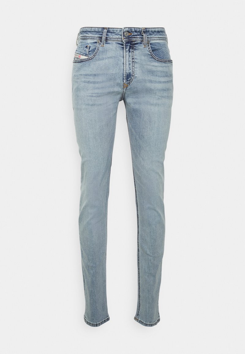 Jeans de mezclilla azul claro con un corte ajustado, cinco bolsillos, costuras en contraste y un sutil desgaste. Cuenta con cremallera y cierre de botón.