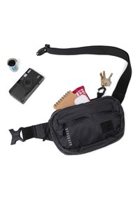 Black nylon fanny pack with a grid pattern, adjustable strap, and buckle. Includes a notebook, camera, film, and keys on a table.