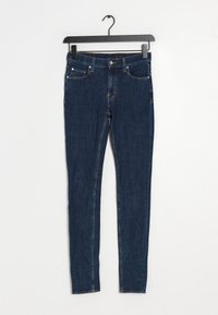 Tmavě modré džínové skinny džíny s středním pasem, pěti kapsami, oranžovým prošíváním a standardním zapínáním na knoflíky.