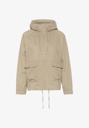 Chaqueta ligera color beige con capucha, cremallera frontal, dos grandes bolsillos, puños elásticos y cordones ajustables en el dobladillo. Textura suave.