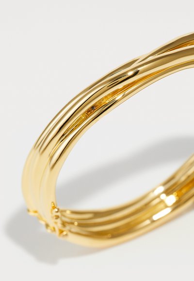 Kuldtooni bangle käevõru, millel on mitu põimunud niiti, millel on sile, peegeldav pind ja poleeritud viimistlus.
