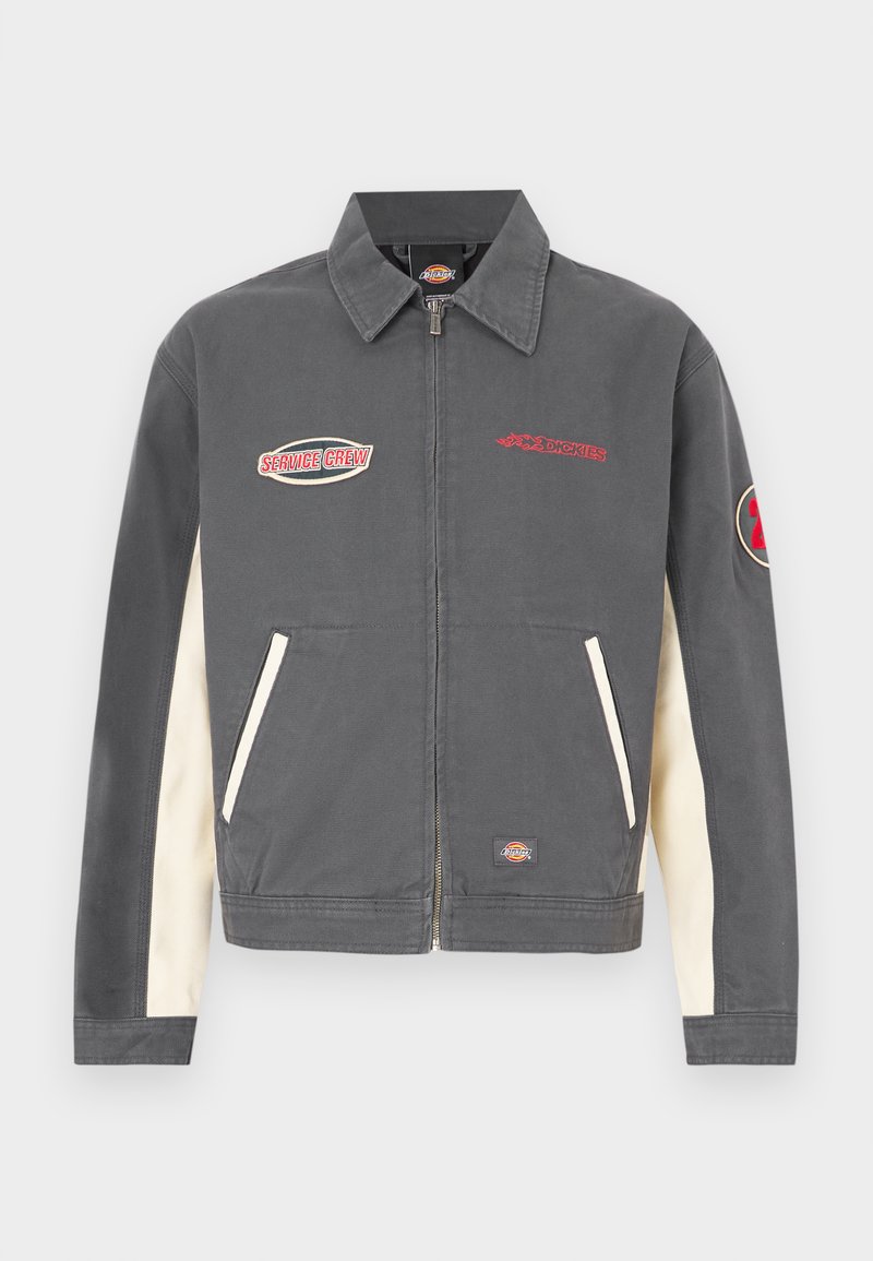 Gray jacket with cream side panels, zip closure, pointed collar, and embroidered logos. Features two front pockets and branded accents.