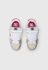 DC sneakers with a white, light gray, and pink color scheme. Features include laces, perforated toe, and signature logo on pink insole.