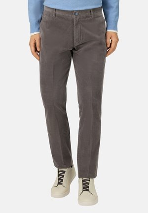 Grijze corduroy broek met horizontale ribbels, slim fit ontwerp, voorzakken, vlakke voorkant en een knoopsluiting. Gecombineerd met lichte sneakers.