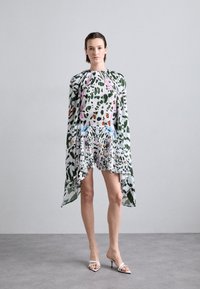 Robe à motifs floraux avec des accents verts, blancs et colorés. Elle présente des manches fluides, un ourlet court et un tissu léger et texturé.