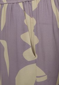 Lila- und beigemusterter Stoff mit abstrakten Formen; weiche Textur mit leichtem Glanz; geraffte Taillendetails.