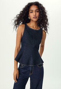 Tmavě modrý bezramenný top s peplum spodním lemem, včetně strukturovaných švů a kontrastního oranžového prošívání. Hladký výstřih a přiléhavý střih.